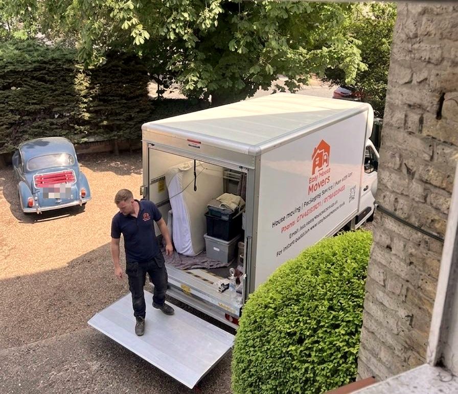 Easy House Movers mover on the tail lift of our branded Luton van during a house move